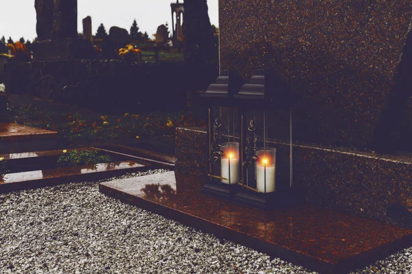 Grave candle light.Graves in a cemetery.Catholic cemetery background. All saints holiday.Grave candles on marble tomb.Gray granite grave.