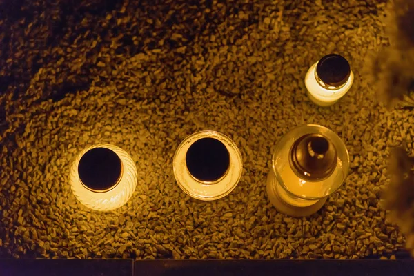 Candles Burning at Night.White Candles Burning in the Dark with lights glow.Focus on candles in foreground.Top view.