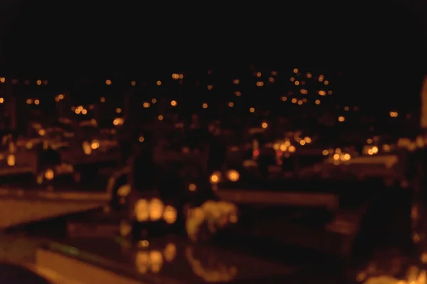 Blurred cemetery Candles Burning at Night.White Candles Burning in the Dark with lights glow background.