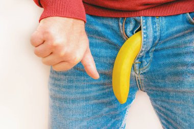 İktidar sorunu kavramı. Muz taklidi yapan erkek pantolonu. El baş parmakları gösteriyor. Sağlık ve erkek cinselliği kavramı..