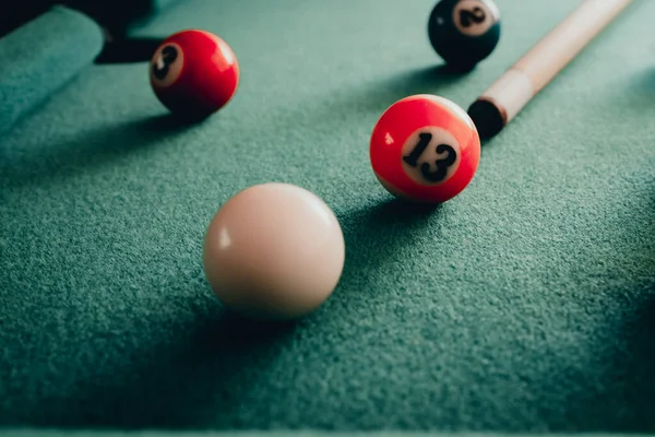 Sports game of billiards on a green cloth.Multi colored billiard balls in the form of a triangle with numbers,a cue ball and a triangle on a pool table. billiard balls closeup.Toned.