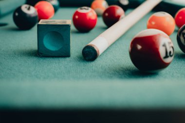Yeşil elbiseli bir bilardo oyunu. İçinde numaralar, bilardo topu ve bilardo masasının üzerinde üçgen olan çok renkli bilardo topları. Bilardo toplarını yakın çekim..