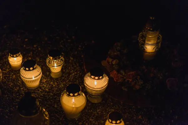 Candles Burning at Night.White Candles Burning in the Dark with lights glow.Focus on candles in foreground.