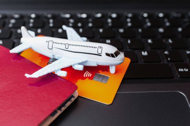 Seyahat hazırlama konsepti. Oyuncak uçak pasaport ve dizüstü bilgisayar kartı. Yakın plan..