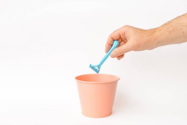 Tek kullanımlık jilet çöpe atılır. Beyaz arka plan, seçici odak, kopyalama alanı.