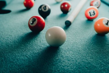 Yeşil elbiseli bir bilardo oyunu. İçinde numaralar, bilardo topu ve bilardo masasının üzerinde üçgen olan çok renkli bilardo topları. Bilardo toplarını yakın çekim..