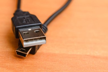 Kahverengi arka planda mikro usb ve usb kablosu. Boşluğu kopyala.