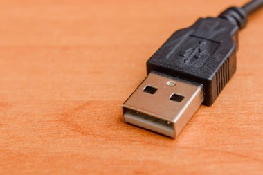 Ofisteki kahverengi ahşap bir masada USB kablosu. Boşluğu kopyala.