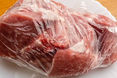 Şeffaf polietilen poşette taze çiğ et, dondurucudan yeni çıkarıldı. Yakın çekim..