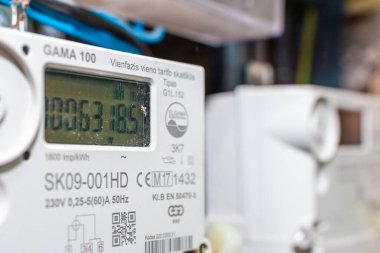 Akıllı elektrik sayacı, dijital ekran güç kullanımı, modern akıllı şebeke yerleşim aracı, kapalı alan, seçici odaklanma, teknoloji konsepti. Yakın plan. Telsiai, Litvanya. 05-26-2025.