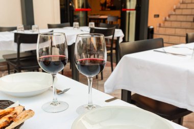 Açık bir kafedeki masada iki kadeh kırmızı şarap. yaz günü.