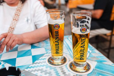 Yaz gecesi açık hava barında iki bira bardağı masanın üstünde duruyor. İtalya, Rimini 06-13-2025.