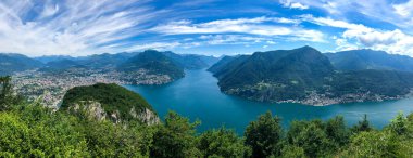 Lugano şehri, Lugano Gölü ve İsviçre Alpleri üzerinde geniş panoramik manzara, Monte San Salvatore gözlem terasından görülebilir, Ticino kantonu, İsviçre.
