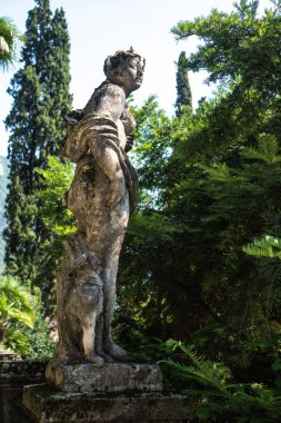 Antik heykel, İtalya 'nın Lecco ilinin Varenna kentindeki ünlü Villa Manastırı' nın botanik bahçesinden göle bakıyor..
