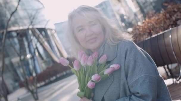 Bankta Çiçekleri Olan Zarif Olgun Bir Kadın Pembe Lalelerle Dolu — Stok video