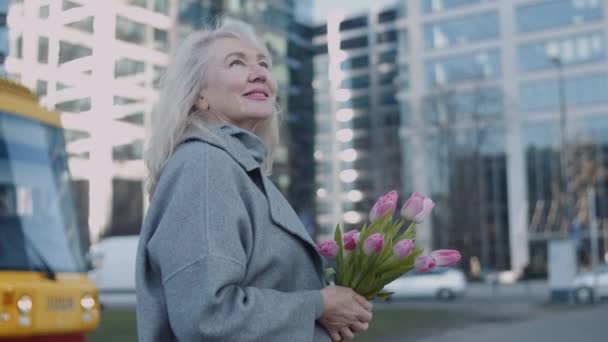 Retrato Uma Mulher Loura Caucasiana Sênior Com Flores Paisagem Urbana — Vídeo de Stock