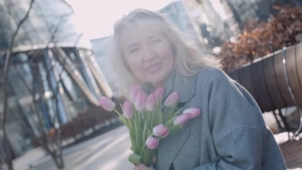 Portret Starszej Białej Blondynki Kwiatami Miejskim Krajobrazie Słoneczny Dzień Wiosna — Wideo stockowe