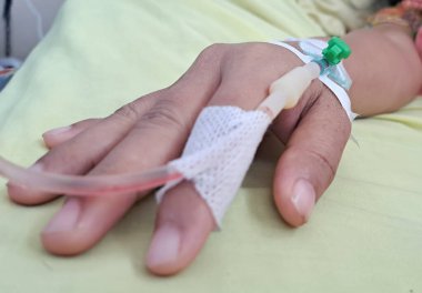 Hastanedeki hastanın eline serum takın. Kadın elini serumla kapat.