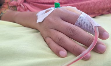 Hastanedeki hastanın eline serum takın. Kadın elini serumla kapat.