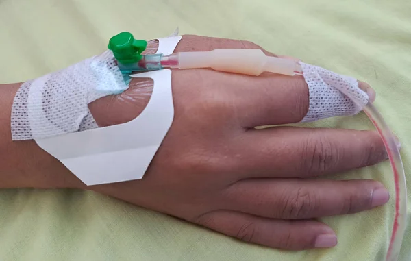 Close up Hand of patient on hospital with IV infusion. Close up of female hand with IV drip
