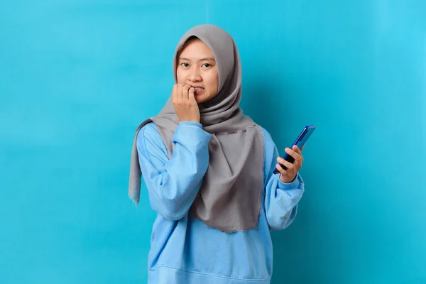 Zdjęcie Nerwowej Wystraszonej Indonezyjskiej Kobiety Trzymającej Smartfona Niepokojącym Wyrazem Twarzy — Zdjęcie stockowe