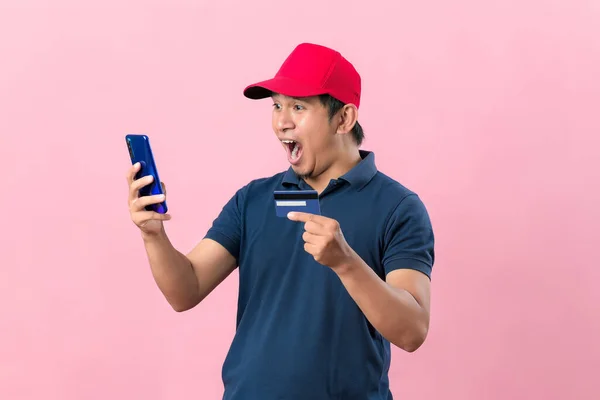 Zszokowany Młody Azjata Luźnej Koszulce Czapką Telefonem Komórkowym Kartą Kredytową — Zdjęcie stockowe