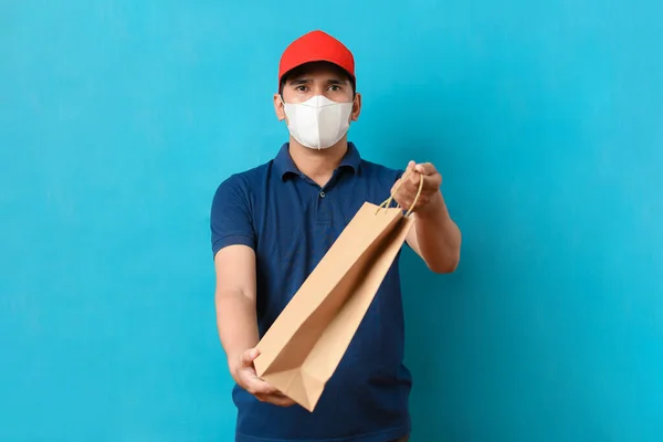 Serviço Entrega Homem Usando Máscara Facial Com Uniforme Azul Segurar — Fotografia de Stock