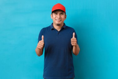 Mutlu teslimatçı, jest, gülümseme, iyi hizmet öneriyor, mavi arka planda izole edilmiş.
