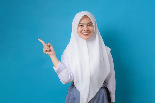 Happy Indonesia Student Wijst Een Kopieerruimte Glimlachend Blauwe Achtergrond — Stockfoto