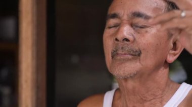 Yaşlı bir adam sigara içiyor.