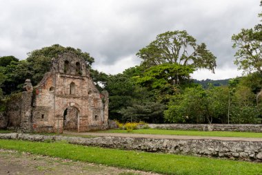 Ujarras, Kartaca, Kosta Rika 'daki sömürge dönemine ait bir kilisenin kalıntıları. Bina yeşillik ve çiçeklerle çevrili, girişe giden açık bir yol var.