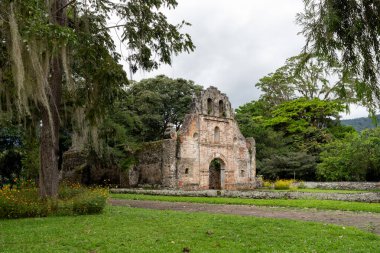 Ujarras, Kartaca, Kosta Rika 'daki sömürge dönemine ait bir kilisenin kalıntıları. Bina yeşillik ve çiçeklerle çevrili, girişe giden açık bir yol var.