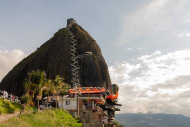 Zirveye çıkan merdivenleri ve Guatape, Antioquia, Kolombiya 'da renkli bir turizm bölgesini içeren El Penol Kayası manzarası.