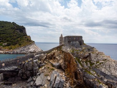 Kuzeybatı İtalya 'nın Ligurian kıyısındaki Porto Venere köyünde kayalık bir burnun üzerinde oturan Aziz Peter Chiesa di San Pietro' nun Gotik tarzı kilisesinin güzel hava manzarası. Yüksek kalite