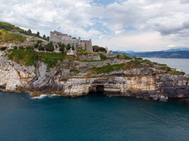 Kuzeybatı İtalya 'nın Ligurian kıyısındaki Porto Venere köyünde kayalık bir burnun üzerinde oturan Aziz Peter Chiesa di San Pietro' nun Gotik tarzı kilisesinin güzel hava manzarası. Yüksek kalite