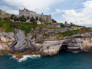 Kuzeybatı İtalya 'nın Ligurian kıyısındaki Porto Venere köyünde kayalık bir burnun üzerinde oturan Aziz Peter Chiesa di San Pietro' nun Gotik tarzı kilisesinin güzel hava manzarası. Yüksek kalite