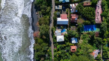 Playa Negra plajının insansız hava aracı görüntüsü, güzel bitki örtüsü ve siyah kumlu tropikal plaj, Punta Uva, Puerto Viejo, Kosta Rika. Yüksek kalite fotoğraf