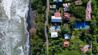 Playa Negra plajının insansız hava aracı görüntüsü, güzel bitki örtüsü ve siyah kumlu tropikal plaj, Punta Uva, Puerto Viejo, Kosta Rika. Yüksek kalite fotoğraf