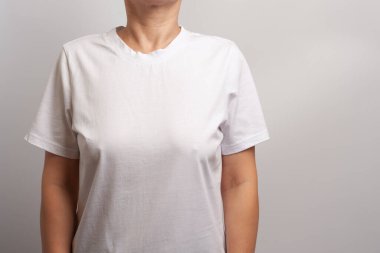 Beyaz tişörtle poz veren yetişkin bir kadın model. Ön görünüm