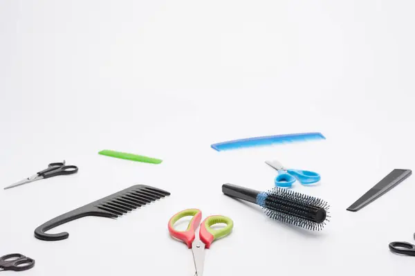 Kuaför seti. Beyaz arka planda bir saç fırçası, tarak ve farklı makas deseni.