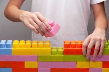 Genç adamın elleri yapbozun son parçasını birleştirir.