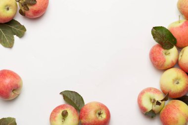 Beyaz arka plandaki hasır plakada sulu olgun elmalar. Yüksek açı görünümü