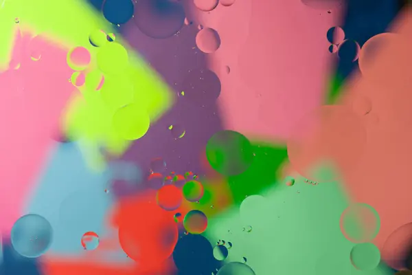 Su yüzeyindeki bulanık ve renkli arkaplanlı yağ kabarcıklarının soyut görüntüsü