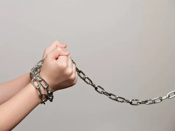 Gençlerin elleri metal bir zincirle bağlanmış. Çocuk suçluların sosyal sorunu.