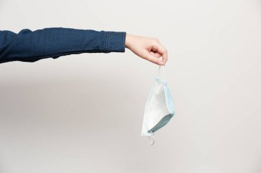 İnsan eli, tamamen iyileştiğini gösteren koruyucu tıbbi maskeyi fırlatır.