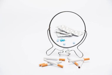 Yaratıcı kompozisyon. Sigaralar aynadaki haplar gibi yansıyor.