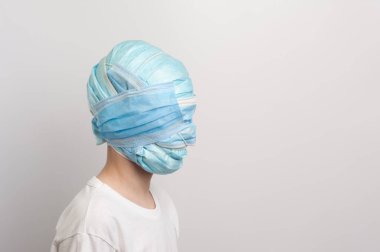 Tıbbi maskelerle sarılmış bir adam. Tıbbi konuların yaratıcı bileşimi