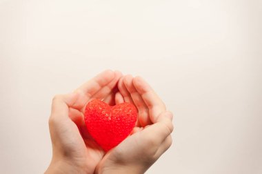 Kırmızı bir kalp tutan çocukların elleri