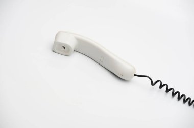 Beyaz arkaplanda siyah kablo bulunan beyaz bir cep telefonu.