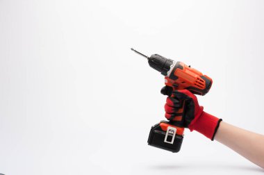 Kırmızı eldivenli bir işçi eli beyaz arka planda elektrikli tornavida tutuyor.